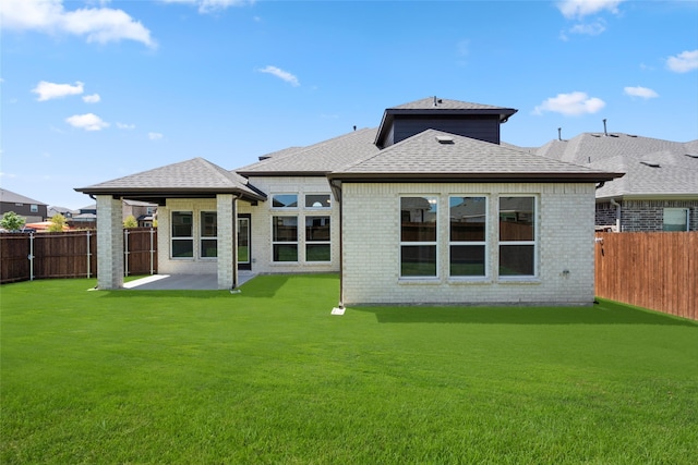 rear view of house featuring a patio and a yard