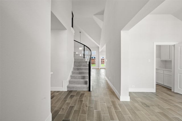 interior space with high vaulted ceiling and light hardwood / wood-style flooring