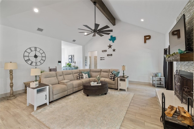 living room with a fireplace, lofted ceiling with beams, light hardwood / wood-style floors, and ceiling fan