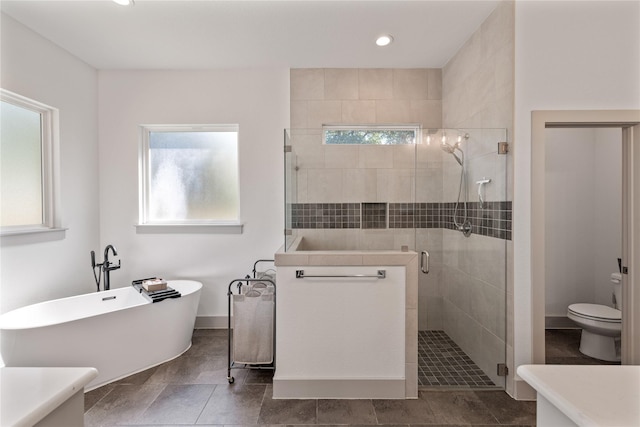 full bathroom featuring shower with separate bathtub, vanity, and toilet