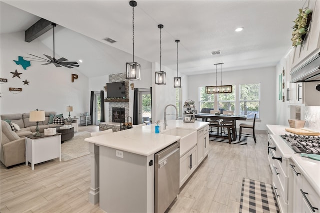 kitchen featuring dishwasher, sink, white cabinetry, and a kitchen island with sink