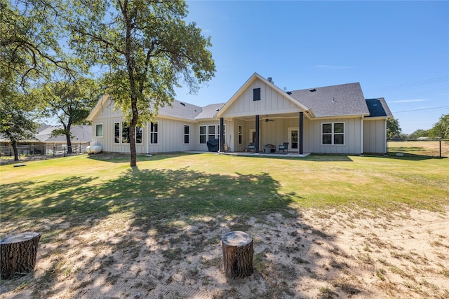 back of house with ceiling fan and a lawn