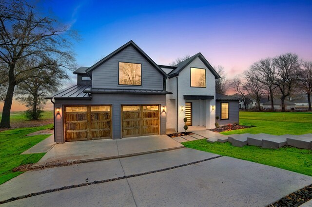 modern farmhouse style home featuring a yard and a garage