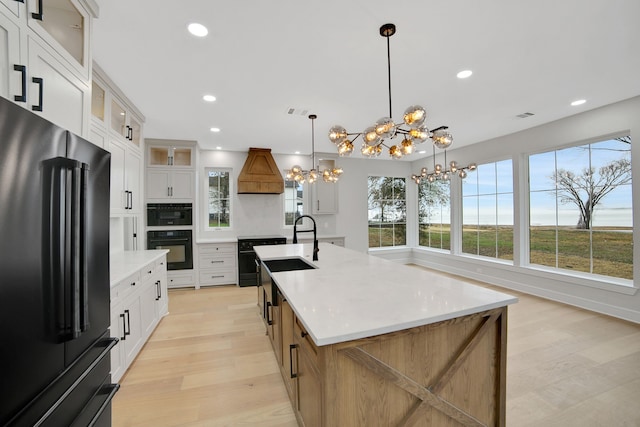 kitchen featuring white cabinetry, a large island, and high end black refrigerator