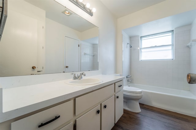 full bathroom featuring tiled shower / bath combo, hardwood / wood-style flooring, vanity, and toilet