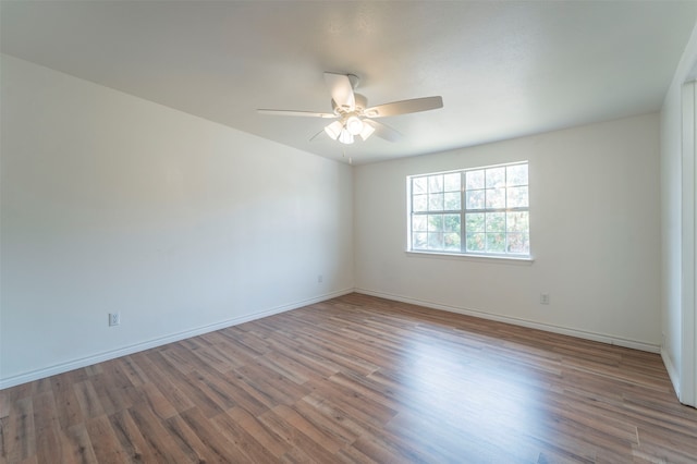 empty room with hardwood / wood-style floors and ceiling fan