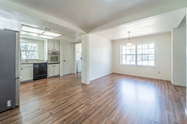 kitchen with appliances with stainless steel finishes, white cabinets, hardwood / wood-style floors, and pendant lighting