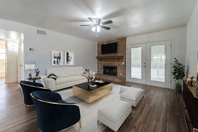 living room with ceiling fan, french doors, wood-type flooring, and a brick fireplace