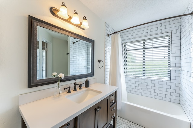 bathroom featuring a textured ceiling, shower / bath combo with shower curtain, vanity, and tile patterned flooring