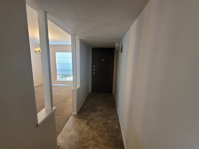 hallway featuring a textured ceiling and tile patterned flooring