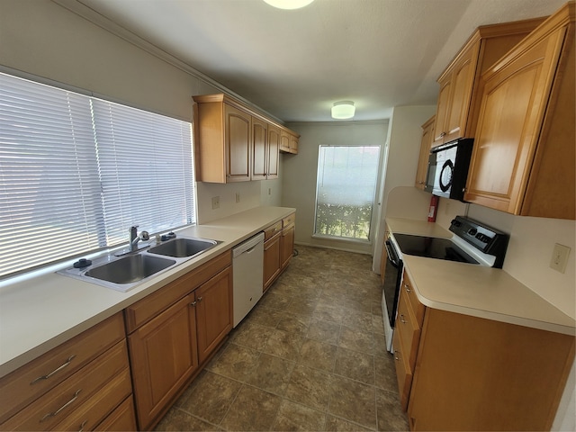 kitchen featuring sink, dark tile patterned flooring, white dishwasher, and electric range