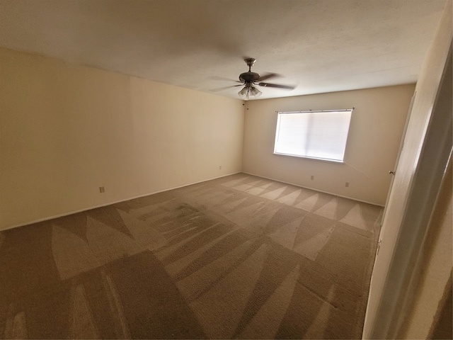 spare room with ceiling fan and carpet