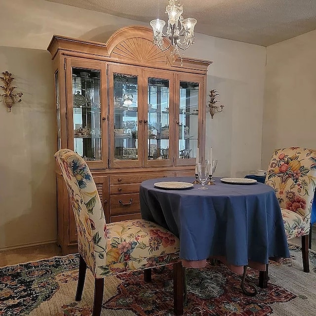 dining room with a notable chandelier, carpet floors, and a textured ceiling