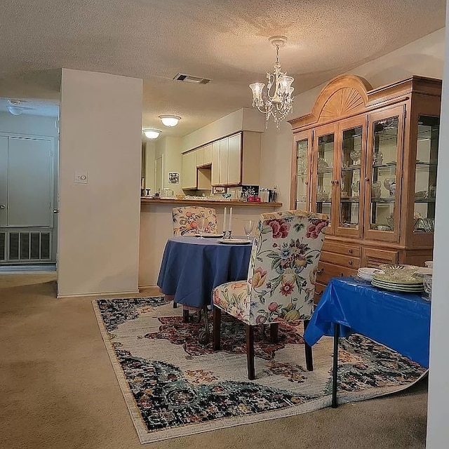 living area featuring a notable chandelier, a textured ceiling, and carpet