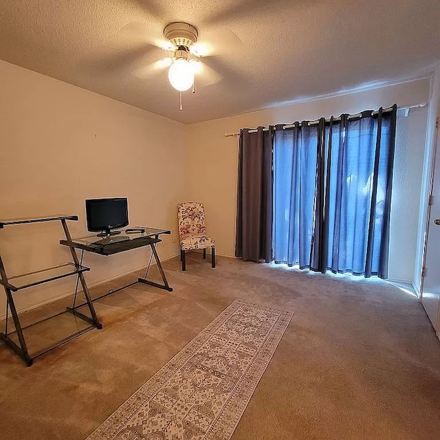 carpeted office with a textured ceiling and ceiling fan