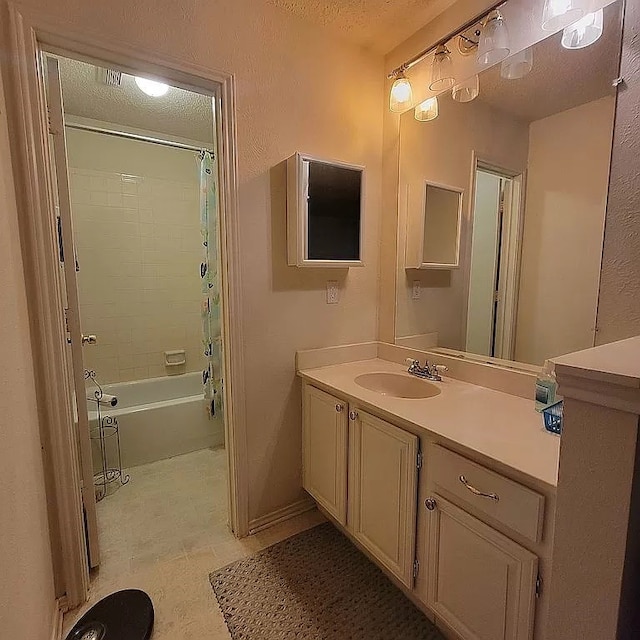 bathroom featuring tile patterned floors, shower / tub combo with curtain, vanity, and a textured ceiling