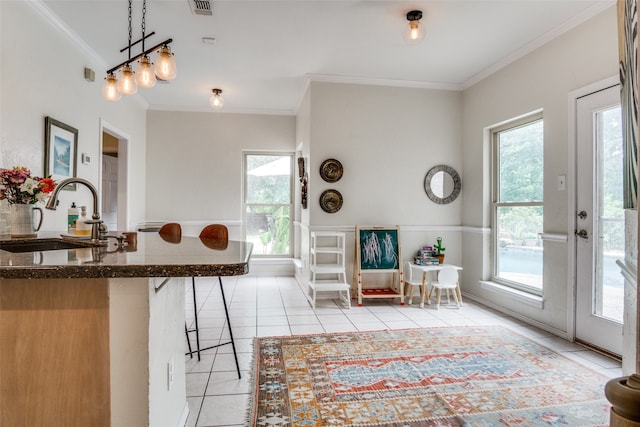 kitchen with sink, pendant lighting, light tile patterned floors, and a healthy amount of sunlight