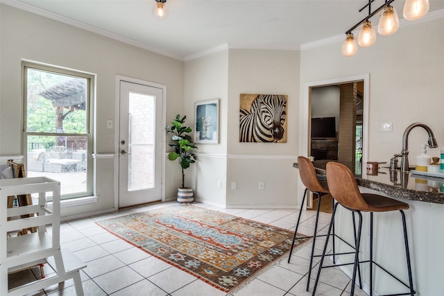 entryway featuring sink, light tile patterned floors, and crown molding