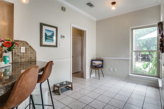 dining space featuring ornamental molding, light tile patterned floors, and a wealth of natural light