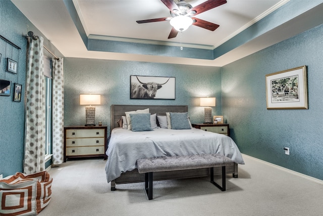 bedroom featuring a tray ceiling, light colored carpet, ornamental molding, and ceiling fan