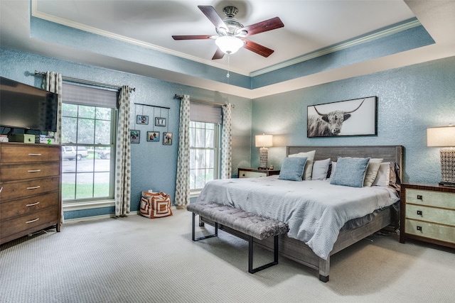 bedroom featuring ceiling fan, crown molding, a raised ceiling, and light colored carpet