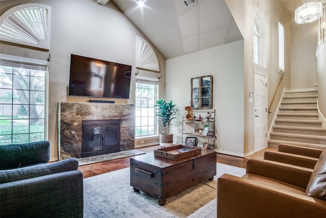 living room featuring hardwood / wood-style floors, a high end fireplace, and a high ceiling