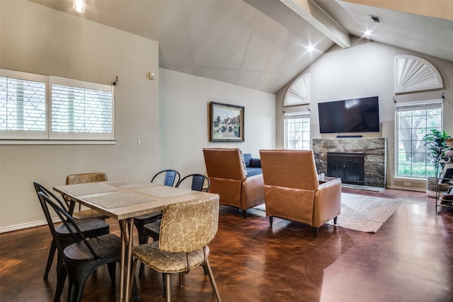 dining space featuring beamed ceiling, a high end fireplace, and high vaulted ceiling