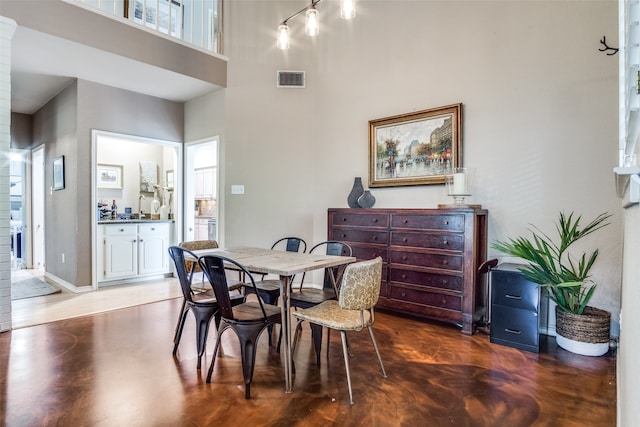 dining area featuring rail lighting, a high ceiling, and a wealth of natural light