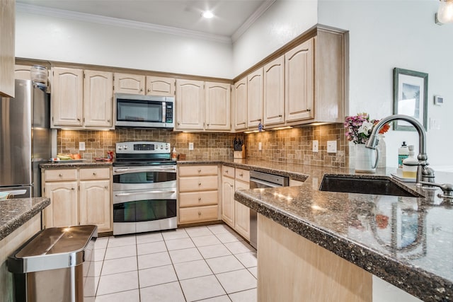 kitchen featuring appliances with stainless steel finishes, sink, light brown cabinets, and decorative backsplash