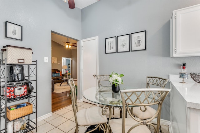 dining space with light tile patterned floors, ceiling fan, and baseboards