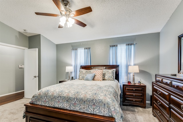 bedroom featuring ceiling fan, a textured ceiling, and carpet floors