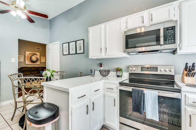 kitchen featuring appliances with stainless steel finishes, light tile patterned flooring, white cabinets, and ceiling fan