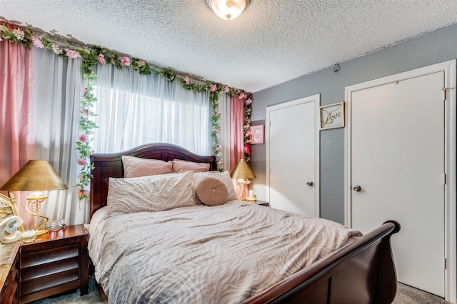 bedroom with a textured ceiling and light carpet