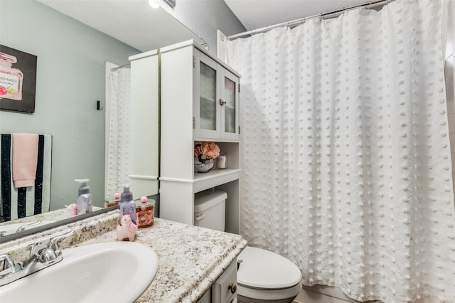 bathroom with vanity, a textured ceiling, and toilet