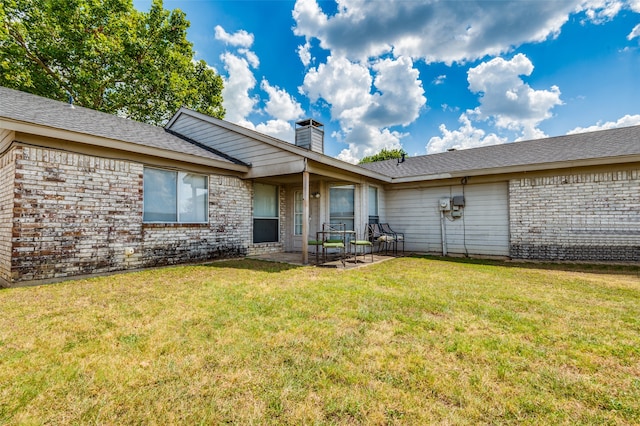 rear view of property featuring a lawn