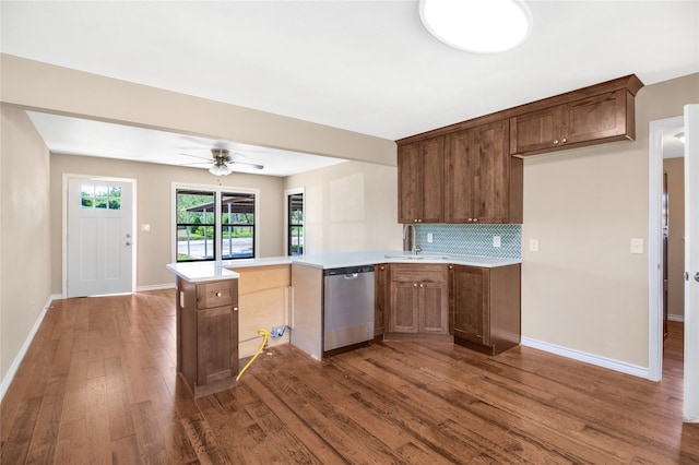 kitchen featuring decorative backsplash, sink, dark hardwood / wood-style flooring, kitchen peninsula, and dishwasher