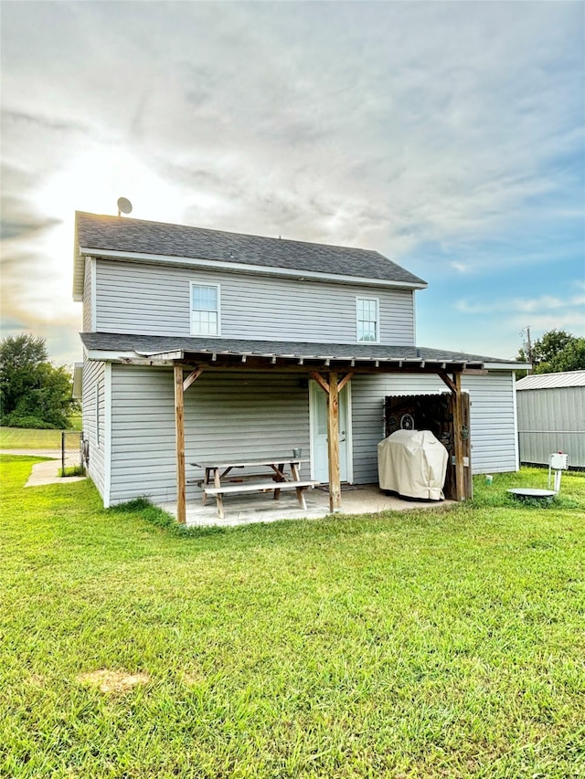 back of house featuring a patio and a yard