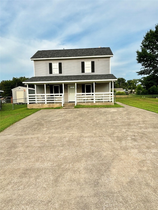 farmhouse-style home featuring an outbuilding, covered porch, and a front yard