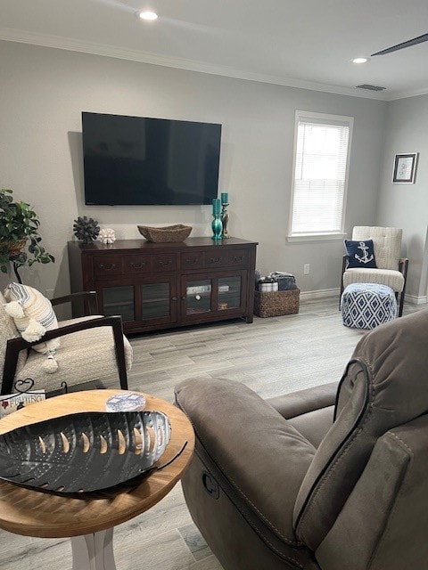 living room with light hardwood / wood-style flooring and ornamental molding