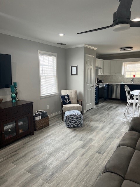 living room featuring light wood-type flooring and ornamental molding