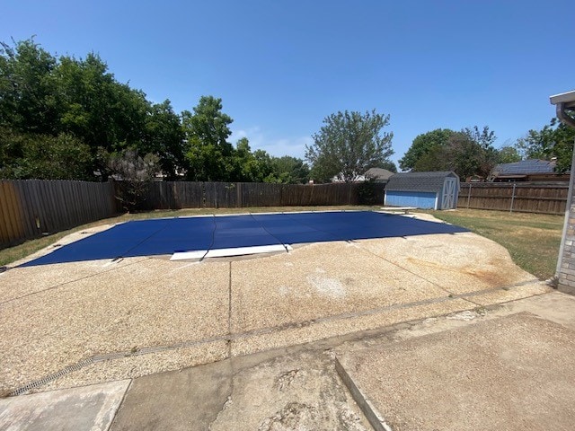 view of swimming pool with a patio and a shed