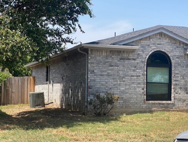 view of home's exterior with central air condition unit and a yard