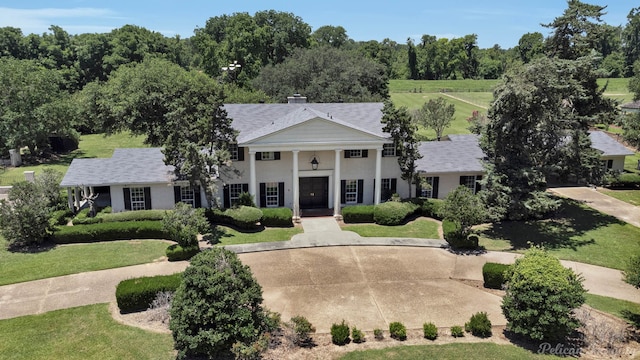 neoclassical / greek revival house featuring a front lawn