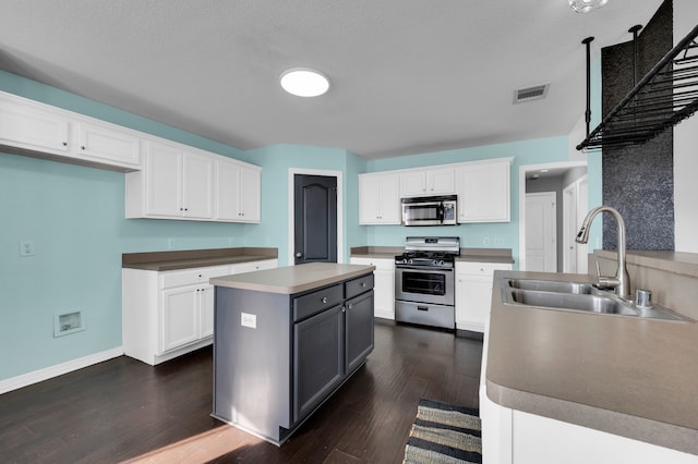 kitchen with white cabinets, dark hardwood / wood-style flooring, stainless steel appliances, and sink