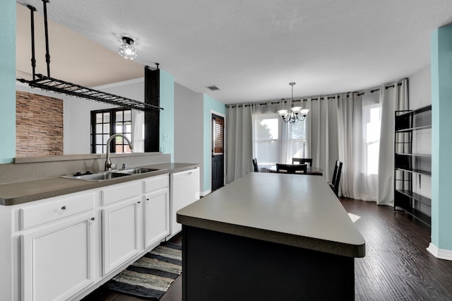 kitchen with dishwasher, a center island, white cabinets, sink, and dark wood-type flooring