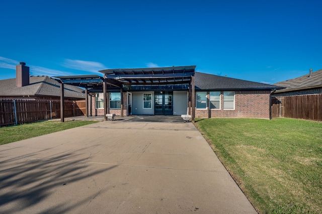 back of property featuring a pergola and a yard