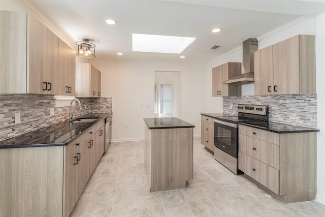 kitchen featuring light brown cabinetry, sink, a kitchen island, stainless steel appliances, and wall chimney range hood