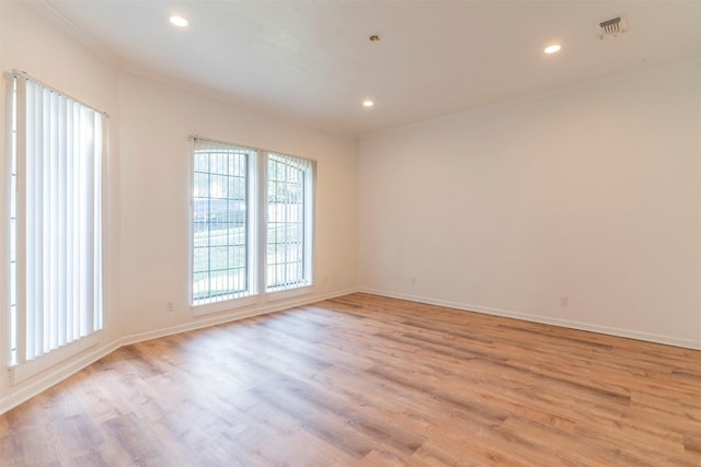 empty room featuring ornamental molding and light wood-type flooring