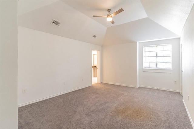 carpeted spare room featuring vaulted ceiling and ceiling fan