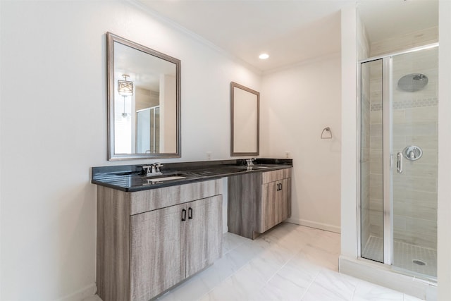 bathroom featuring vanity, ornamental molding, and a shower with door